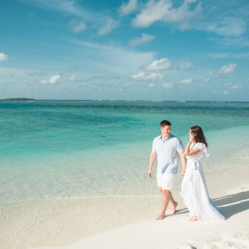 Newlywed couple walking hand in hand along a tropical beach on a Sri Lanka honeymoon tour